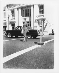 Mid-length dress with a diamond-checked pattern modeled at the mid-block pedestrian crossing on Hinton Avenue near the Topaz Room, Santa Rosa, California, 1959