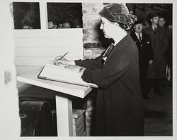 Elizabeth Burbank signing a guest register