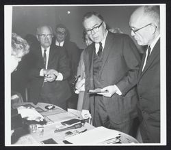 Unidentified group of men examining artifacts