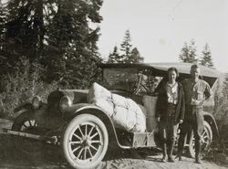 Ethel Raymond and Oliver P. Wheeler standing in front of the Raymond's Overland touring car, about 1920