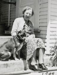 Lillie La Verne Penrod Allen sitting on her front steps with a dog, 309 Pleasant Street, Petaluma, California, 1949