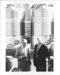 Ed Gauer and Allan Hemphill standing in front of wine storage tanks in, Alexander Valley, Sonoma County, California