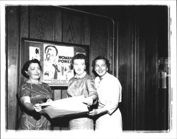 Ruth Snodgrass, Jessie Mitchell and Betsy McLaughlin in front of a National Business Women's Week poster, Petaluma, California, 1958