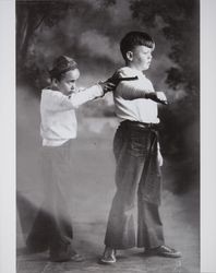 Thomas Herbert Ware and Bobby Mennter play cops and robbers in a photography studio, Santa Rosa, California, about 1930