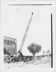 Hook and ladder fire truck with ladder extended to full height, Petaluma, California, 1959