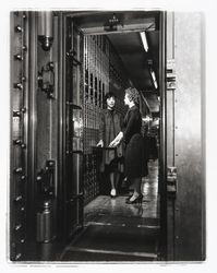 Two women in the vault containing safe deposit boxes at the Exchange Bank