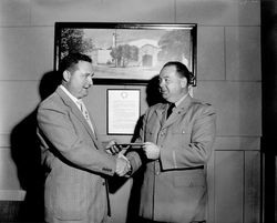 Gene Benedetti giving an envelope to an unidentified man