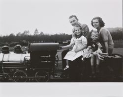 Bud, Mary, Bonnie and Bill Alwes seated on a miniature train, Santa Rosa, California, 1950