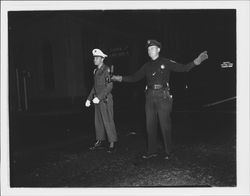 Directing traffic at night in front of the Bank of America building, Petaluma, California, 1950