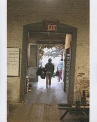 Christina Garcia holding bags goes out of the Sunset Line & Twine Co. building on Dec. 7, 2006