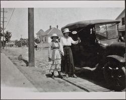 Bernice Torliatt and friend standing near a parked car, Howard Street and Bassett Street, Petaluma, California, about 1910