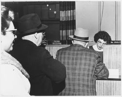 Mrs. Bradley, a teller, serving customers at an unidentified bank, later 1940s or 1950s