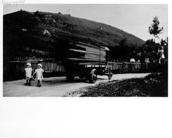 June and Jewell Thorpe standing near a truck hauling lumber