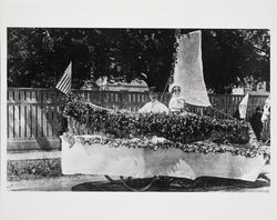 F. M. Bruer with float decorated with poppies and roses in form of a ship--Raymond Bruer riding on float