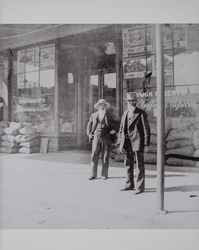 Two unidentified gentleman stand in front of the Hugh Roberts general store in Petaluma, California, photographed between 1900 and 1910