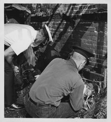 Petaluma Fire Department investigators examining burned electrical equipment after an unidentified fire in Petaluma, California, 1950s or 1960s