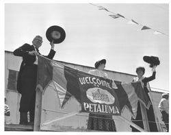 Ed Mannion with two women holding a Welcome to Petaluma banner, Petaluma, California, 1958