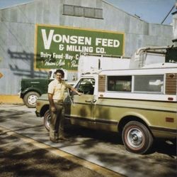 Paul A. Lewis standing next to a pickup truck at Vonsen Feed & Milling Company, Petaluma, California, about 1973