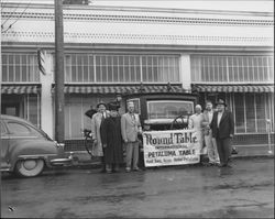 Men holding a sign for meeting of Round Table International., Petaluma, California, 1955