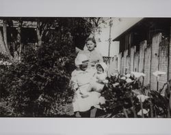 Emma E. Wood sits in her garden with an unidenfied child and woman, Petaluma, California, photographed between 1935 and 1940