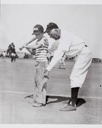 Oscar Vitt, an instructor with the San Francisco Examiner, demonstrates batting stance for unidentified boy, Petaluma, California, July 1954