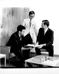 Three unidentified men looking at a law book at Empire College, Santa Rosa, California, 1970