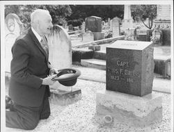 Clarence Connolly kneeling at the grave of Captain Thomas F. Baylis in Petaluma, California, in 1955