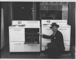 Rex Hardware salesman, George Dickerson standing front of a stove outside the store at 3-5 Main Street, Petaluma, California, about 1938