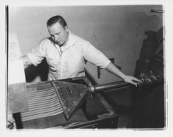 Unidentified worker feeding extruded strips of Slivers dog food into the oven at Gro-Kote, Santa Rosa, California, 1964