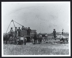 Hay balers posing beside a J. R. Monarch hay press