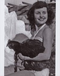 Jacque Rupe holding a chicken, Petaluma, California, about 1947