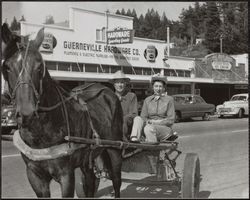 Nin and Helen Guidotti riding in their sulky, Main Street, Guerneville, California, April 11, 1954