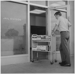 Don Gass pushing a book truck at the Jail Division