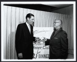Vernon Phillips handing a ticket to an unidentified man for Flamingo Dinner Club, Santa Rosa, California, 1962