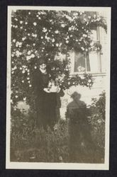 Joyce V. Drake by a climbing rose in the front yard of the Drake residence, 431 Tenth Street, Santa Rosa, California, 1921
