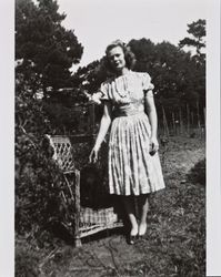 Mary McGregor standing next to a chair with one of Dagny Juell's dogs sitting in it, Santa Rosa, California, about 1945