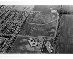 Aerial view of North McDowell Boulevard area of Petaluma, California showing Lynch Creek East Madison Street, Bernard Eldredge School, Maria Drive, Lucchesi Park, and Plaza North Shopping Center, 1973