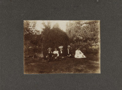 Five people sitting in a park or backyard