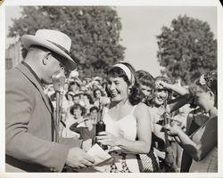 Lila Rulofson receiving a trophy from Leon Adams