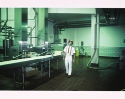 Derrick Cooper standing by the cheese packaging towers at the California Cooperative Creamery on Western Avenue, Petaluma, California, 1983