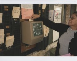 Maria Estella Sanchez using punch time clock, Sunset Line & Twine, Petaluma, California, Dec. 2006