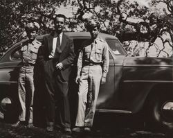 Bud Alwes and two unidentified men standing in front of a car, circa 1945