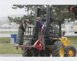 Tim Rhodes and Juan Rodriguez ride on a forklift outside of the Sunset Line & Twine Company building in Petaluma, California, while "Big" Dennis Henderson drives it, Dec. 2006