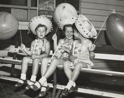 Three little girls enjoy the Sonoma County Fair with popcorn and balloons, Santa Rosa, California, 1957