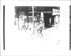 Boy on bicycle in front of Bauer and Schluckebier Hardware, Petaluma, California, 1892