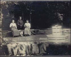 Two women and a man seated at a well or spring, Sonoma County, California, between 1900 and 1910