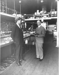 Clarence Braren and A. F. Tomasini standing in the interior of the Tomasini Hardware stores, Petaluma, California in 1921