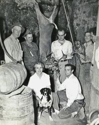 Lily Rossini poses with a dog, her husband, five unidentified men and a recently killed deer, about 1938