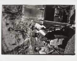 Worker dumping a bucket sand and gravel into the concrete mixer on the site of reconstruction of St. Elizabeth's, Guerneville, California, 1935