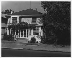 Two-story house with an enclosed porch and numbered as 849 on an unidentified city street, 1950s or 1960s